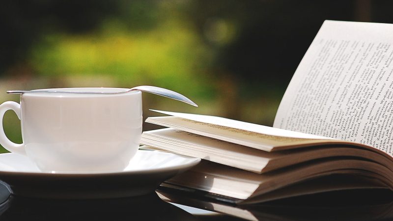 geöffnetes Buch neben einer Kaffeetasse